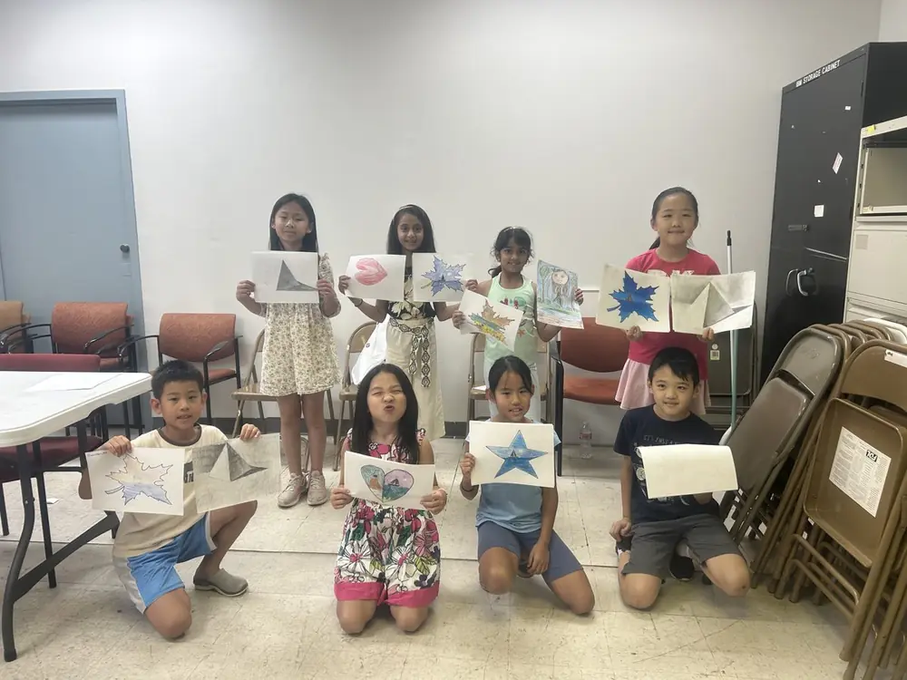 Eight Little Artists students proudly holding up their drawings